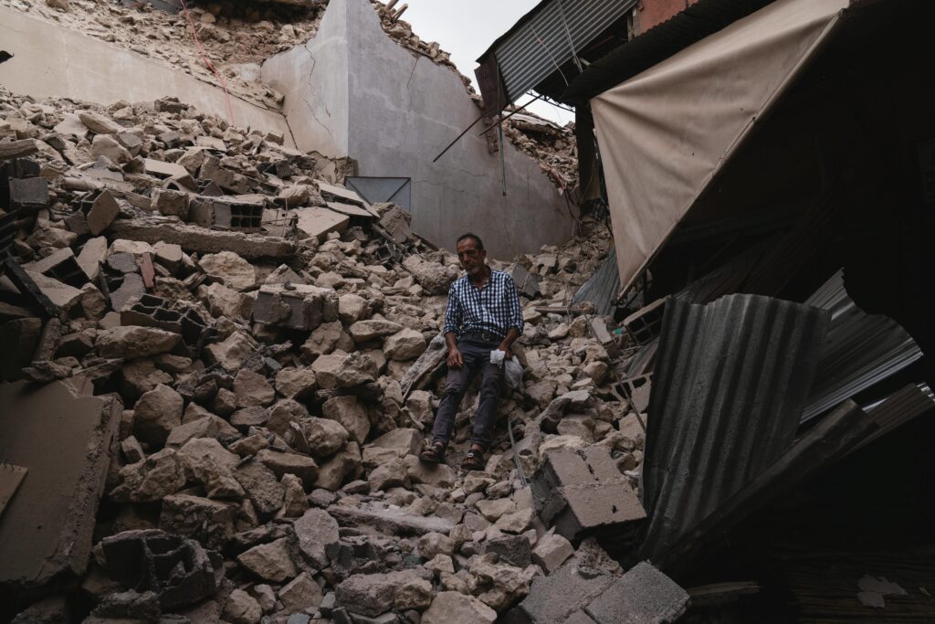 A man sits amidst collapsed buildings and debris following an earthquake in Marrakesh, Morocco.